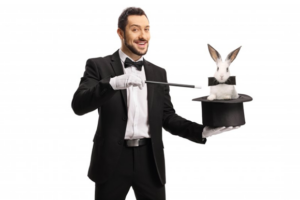 Magician smiling as he makes a rabbit pop out of his hat